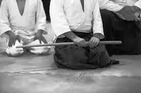 Práctica de Aikido en el dojo: una proyección frente al pergamino de Aikido