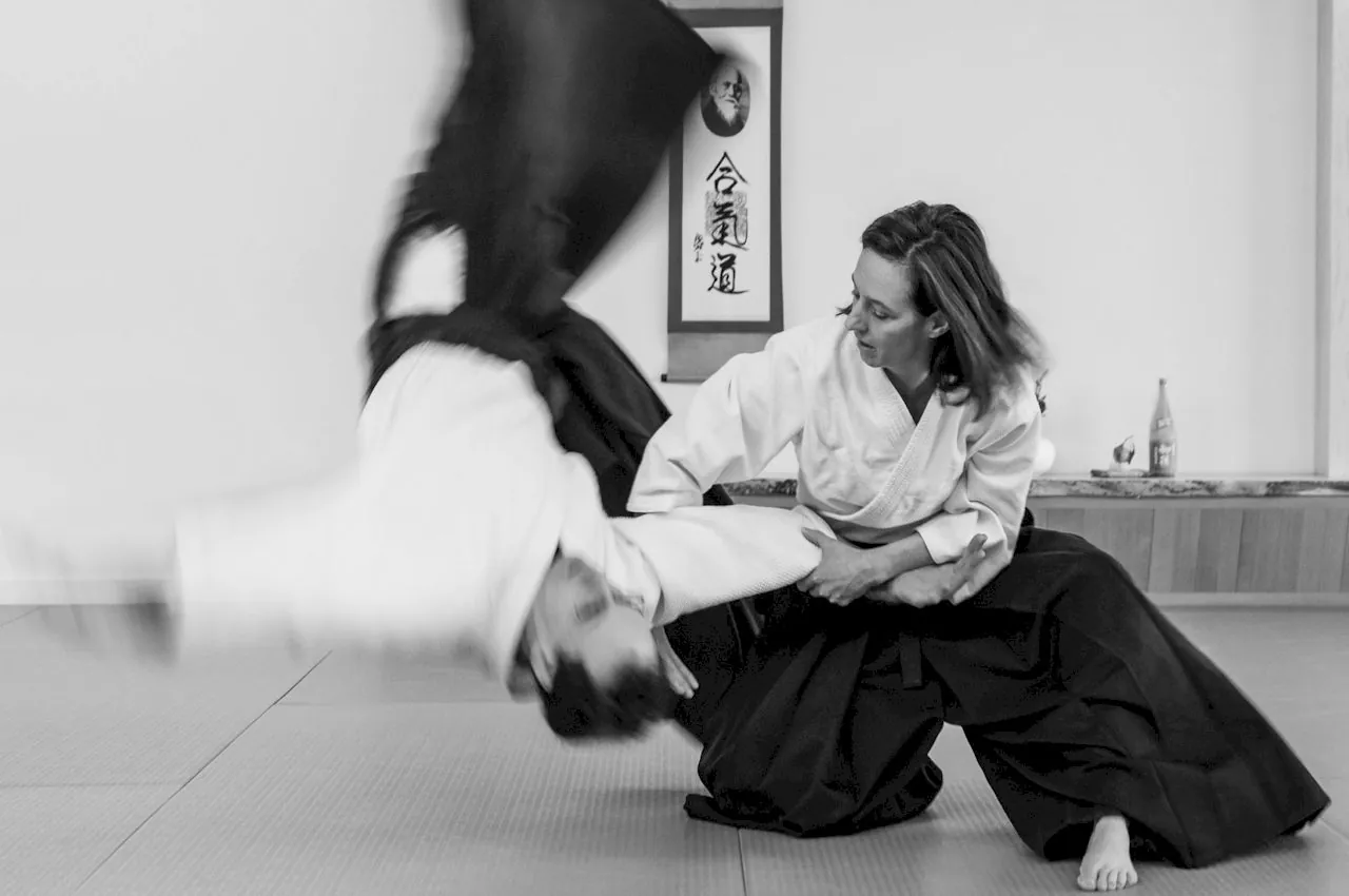 Práctica de Aikido en el dojo: una proyección frente al pergamino de Aikido